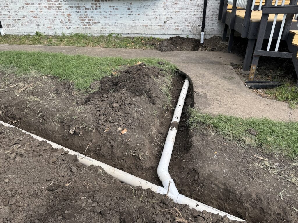 Gutter downspouts tied in to underground drainage system